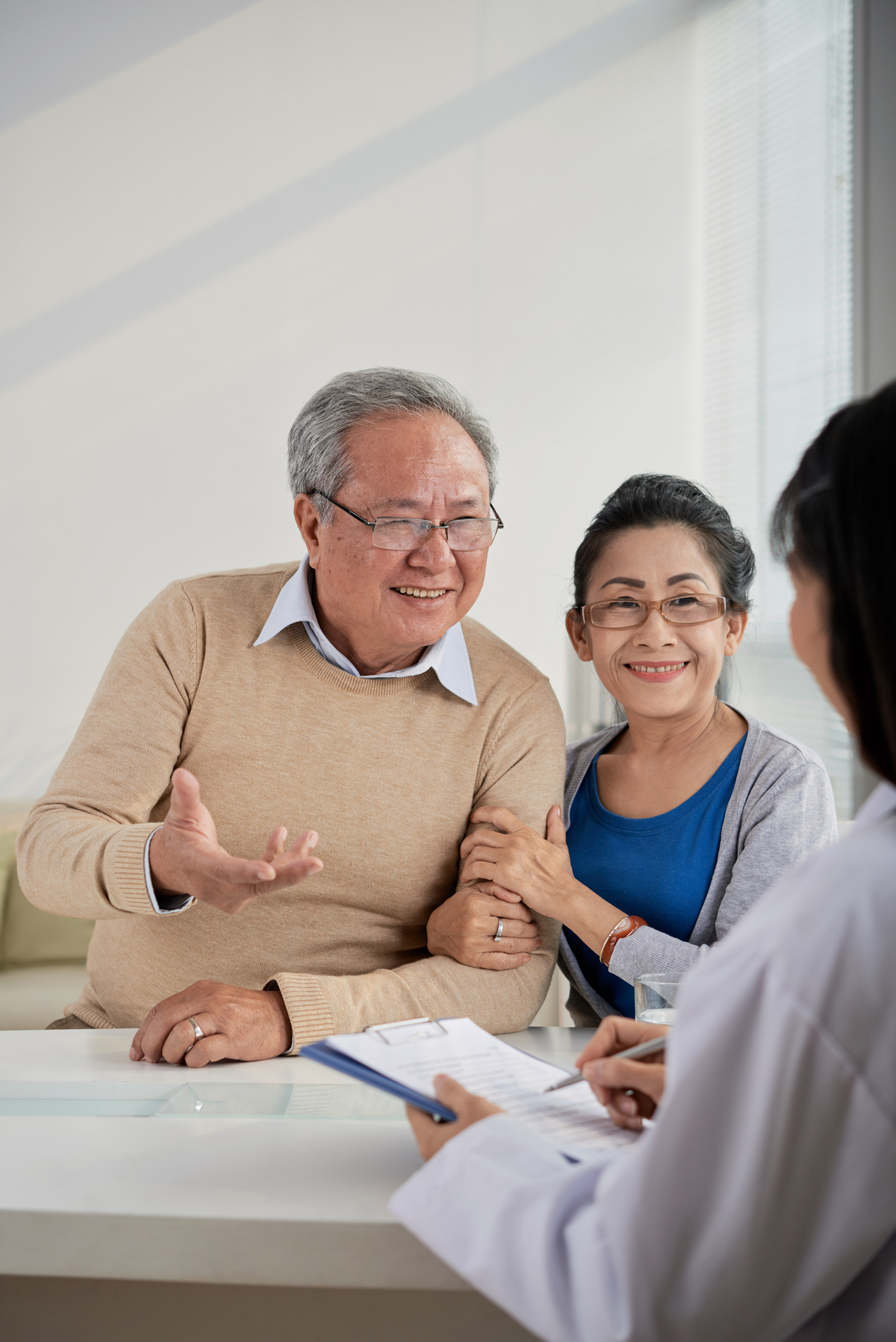 Cheerful senior man and woman talking to real estate manager and telling her their preferences and expectations